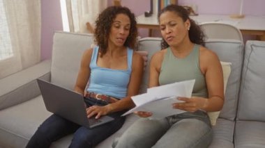 Kadınlar oturma odasında dizüstü bilgisayarla belgeleri tartışıyor.