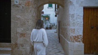 Genç bir İspanyol kadın polignano 'nun büyüleyici taş caddelerinde yürüyor. Bir kısrak, puglia, İtalya, tarihi mimari ve huzurlu bir Avrupa atmosferi ile çevrili..