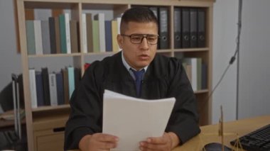 Hakim kılığındaki İspanyol genç adam kütüphane geçmişi olan belgeleri okuyor.