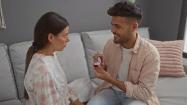 Kadın, evinde elinde yüzük tutan bir adamla evlilik teklifini reddediyor. Samimi bir ortamda sürpriz ve üzüntü sergiliyor..