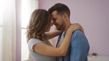 Erkek ve kadın sıcak bir evde kucaklaşıyorlar, kapalı bir yerde sevgi ve şefkat gösteriyorlar.