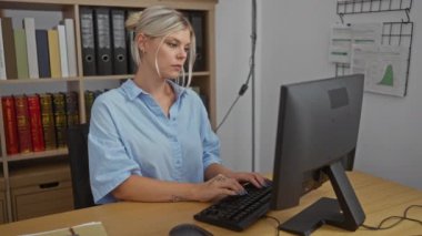 Arkaplanda raflar ve çizelgeler olan bir ofis masasında koluna hapşıran genç bir kadın.