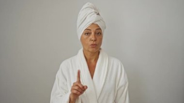 Kafasında havluyla bornoz giymiş olgun bir kadın. Hayır diyor. Parmağını beyaz duvara dayamış.