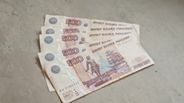 Rus rublesi, Rusya 'dan gelen para birimine odaklı finansal temayı gösteren gri beton bir yüzeye yayılmış..