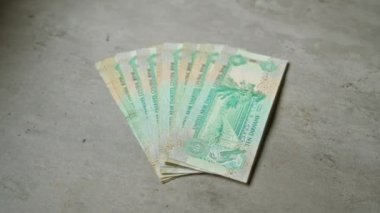 Birleşik Arap Emirlikleri on dirhem banknotlar beton bir yüzey üzerinde yelpazelenmiş bir tarzda düzenlenmiştir.