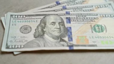 Amerika Birleşik Devletleri 'nin, ABD' nin Benjamin Franklin 'in portresi ve güvenlik özelliklerine odaklanarak somut bir yüzey üzerindeki 100 dolarlık banknotların yakın çekimleri..