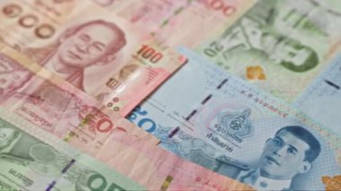 Tayland 'ın çeşitli para birimlerinden çeşitli desenler ve tasarımlar içeren renkli Tayland baht banknotları..