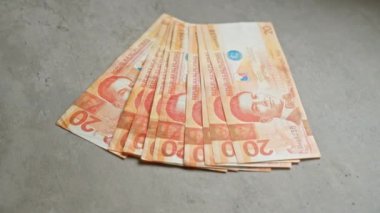 Filipin 20 pezosu somut bir yüzeye yayılmış para birimi detayları ve Manuel Quezon 'un portresi sergileniyor..