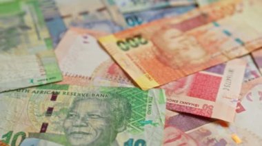 Nelson Mandela 'nın yakın çekimde dağıtıldığı Güney Afrika banknotları çeşitli mezhepleri ve renkli tasarımları vurguluyor.
