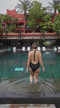 Bali tatil köyündeki havuzda tropik arka planda dinlenen kadın
