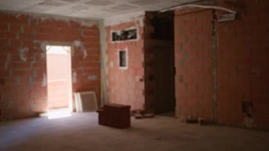 Tamamlanmamış bir inşaat alanının bulanık görüntüsü. Açık bir kapısı ve yerde tuğlaları var.