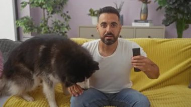 Neşeli bir İspanyol evcil köpeğiyle evinin oturma odasında selfie çekiyor..