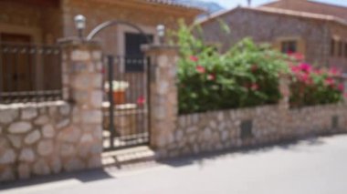 Açık hava Mallorca İspanya 'sında canlı pembe çiçekleri olan taştan bir evin bulanık manzarası.