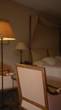 Ön planda şık bir antika sandalye. Arka planda bulanık bir otel odası ve örtülü bir yatak..