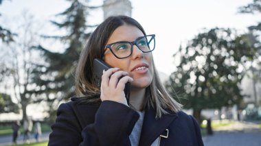 İstanbul 'da bir parkta akıllı telefondan konuşan genç bir kadın, tarihi Türk şehrinde kentsel iletişimi resmediyor..