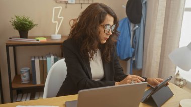 Profesyonel orta yaşlı bir kadın modern bir ofis ortamında tablet üzerinde çalışıyor..