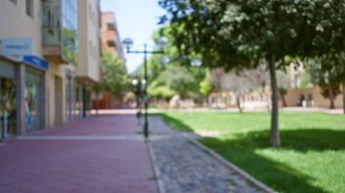 Bokeh efektli bulanık sokak sahnesi odaksız bir park ve açık şehir ortamını gösteriyor