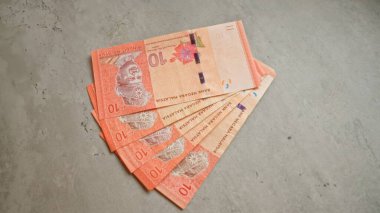 Malezya halka banknotları beton bir yüzeye saçılmış Malezya 'dan gelen canlı para birimini vurguluyor.