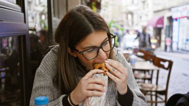 Yetişkin İspanyol kadın Avrupa 'da bir şehir caddesinde kebap yiyor. Turizm ve şehir yemekleri öneriyor..