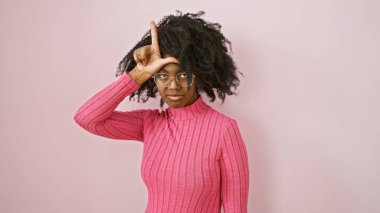 Pembe elbiseli, gözlüklü Afro-Amerikan kadın.