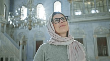 İstanbul 'da gözlüklü ve tesettürlü sakin bir kadın İslami camiye hayran.