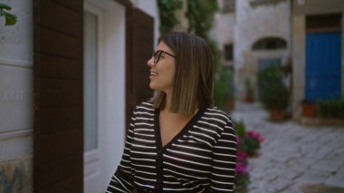 Genç bir İspanyol kadın polignano 'nun büyüleyici sokaklarında yürürken güzel bir günün tadını çıkarıyor. Bir kısrak, puglia, İtalya, benzersiz Avrupa mimarisi ve canlı atmosferini gözler önüne seriyor..