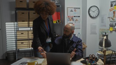 A man and woman, appearing as detectives, analyze evidence in a cluttered police station office. clipart