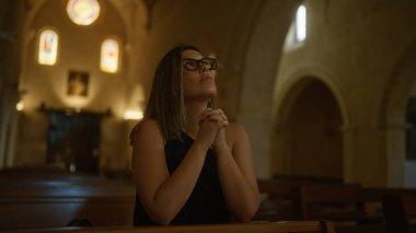 Güzel, genç, İspanyol bir kadın İtalya 'da tarihi bir Hıristiyan kilisesinde dua ediyor. Etrafı boyalı camlarla çevrili ve dindar bir atmosferle çevrili..