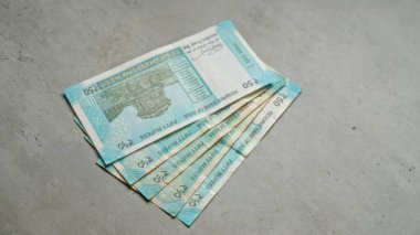 Somut bir yüzey üzerinde 50 rupilik Hint banknotları, para ve finans temasını betimliyor..