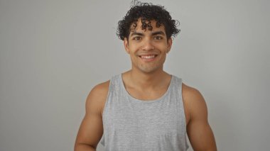 Yakışıklı, kıvırcık saçlı, beyaz bir arka planda sıradan bir bluzla gülümseyen bir İspanyol.