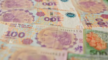 Arjantin 100 pesosu çeşitli düzenlemelerle canlı renkler ve ayrıntılı tasarımlar sergiliyor, Arjantin para birimi ve finansal konseptini temsil ediyor..