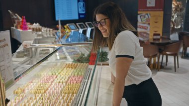 Pastanedeki renkli kurabiyelere hayran olan genç bir İspanyol kadın..