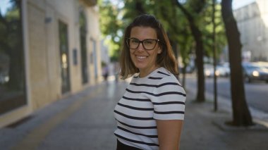 Güzel, genç bir İspanyol kadın gülüyor güneşli bir sokakta dikilirken Lecce, puglia, İtalya 'da.