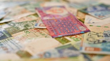 Hong Kong banknotları bir masanın üzerine serpiştirilmiş canlı para çeşitliliğini ayrıntılı olarak gösteriyor..