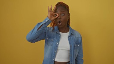 Sarı arka planda kot ceketli Afro-Amerikan bir kadının gözünün üstüne 