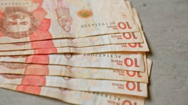 Kolombiya banknotları somut bir yüzey sergisi üzerinde sergileniyor. Düzenli olarak birden fazla 10 peso banknot, Kolombiya 'nın belirgin para birimiyle finansal temayı gösteriyor..