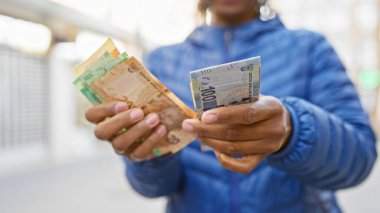 Rand paralarını şehir sokaklarında karşılaştıran Afrikalı bir kadın..