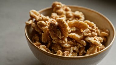 Doğal ışık altında kabuklu organik cevizlerle dolu bir kâse sağlıklı bir atıştırma seçeneği sunar..