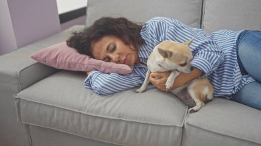 İspanyol bir orta yaşlı kadın ve evcil köpeği rahat evinde bir kanepede dinleniyor, rahatlama portresi çiziyor..