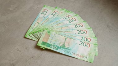 Rus rublesi banknotları somut bir yüzey üzerinde bir yelpazede düzenlenerek para ve mali temalara vurgu yapıyor..