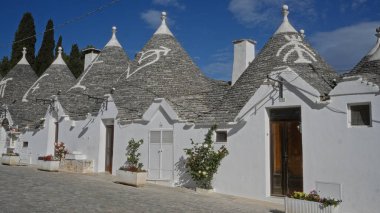 Büyüleyici puglia bölgesinde güneşli bir günde alberobello, İtalya 'da geleneksel trulli evler, belirgin konik çatılar ve beyazlatılmış duvarlar..