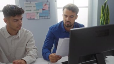 Bir iş toplantısı sırasında, kapalı bir ofiste çalışan İspanyol erkekler kağıtları gözden geçiriyorlar..