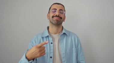 Kot gömlek giyen genç İspanyol adam gülümsüyor ve mutlu, parmak ve el ile göstererek izole beyaz arka plan, kendinden emin ve iyimser sunum jesti