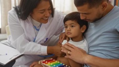Babası tarafından oturma odasında tutulan çocuğu muayene eden doktor.