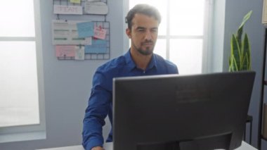 Ofiste birlikte çalışan adamlar, tahtada notlar ve bir adam bilgisayar kullanırken diğeri elinde kahve fincanı tutuyordu.