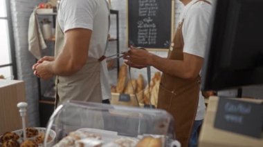 Erkekler kapalı bir pastanede birlikte çalışırlar. Biri diğerinin önlüğünü bağlar. Etrafı çeşitli ekmekler ve pasta gösterisiyle çevrilidir..