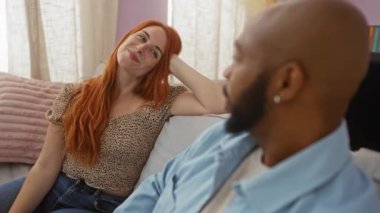 Irklar arası bir çift evde rahat bir anın tadını çıkarıyor. Bir kadın, rahat bir oturma odasında bir adama gülümsüyor..