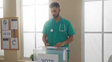 Genç İspanyol erkek doktor, çeşitli pozlarda çekilen ve kapalı bir seçim merkezindeki demokratik süreci vurgulayan bir seçim odasında oy veriyor..