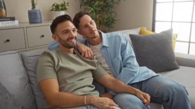 Sıcak bir oturma odasında neşeli sevgi ve mutlulukları evlerinde gösteren bir çifti kutluyor ve televizyon izliyorlar.