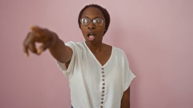 İzole edilmiş pembe arka planda şaşkın şaşkın bakan kadın